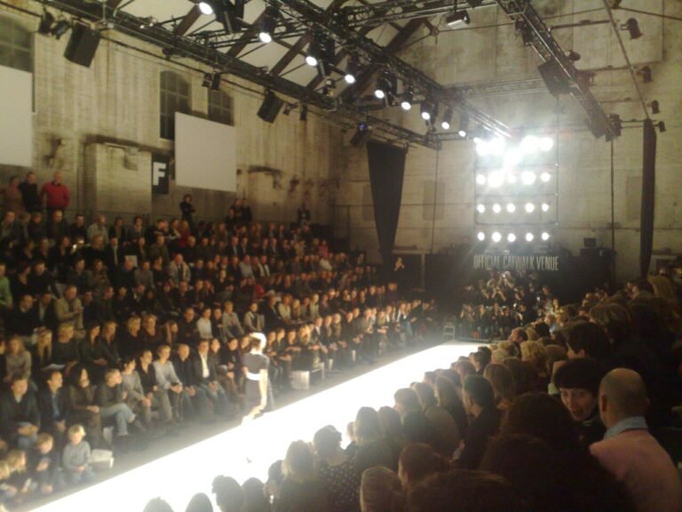Model walking a fashion week catwalk before a live audience
