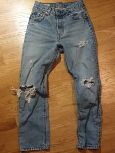 Blue Levi's 501 jeans on a wooden floor