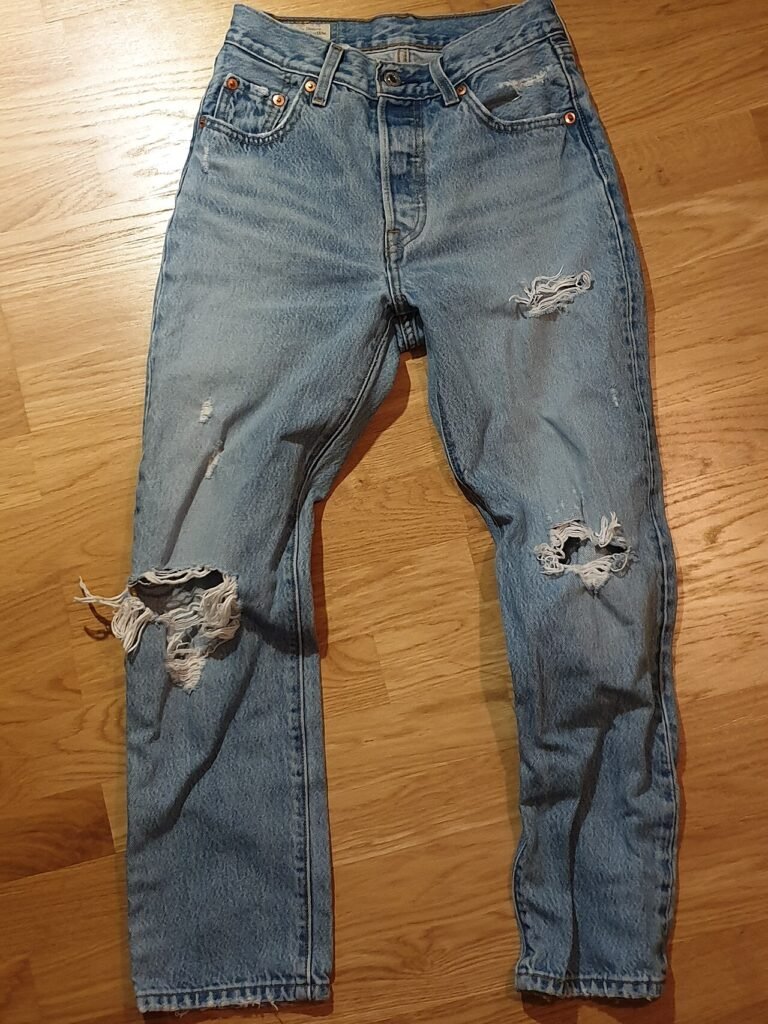 Blue Levi's 501 jeans on a wooden floor