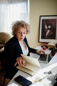 Professional woman working at a desk with laptop and documents in a bright office